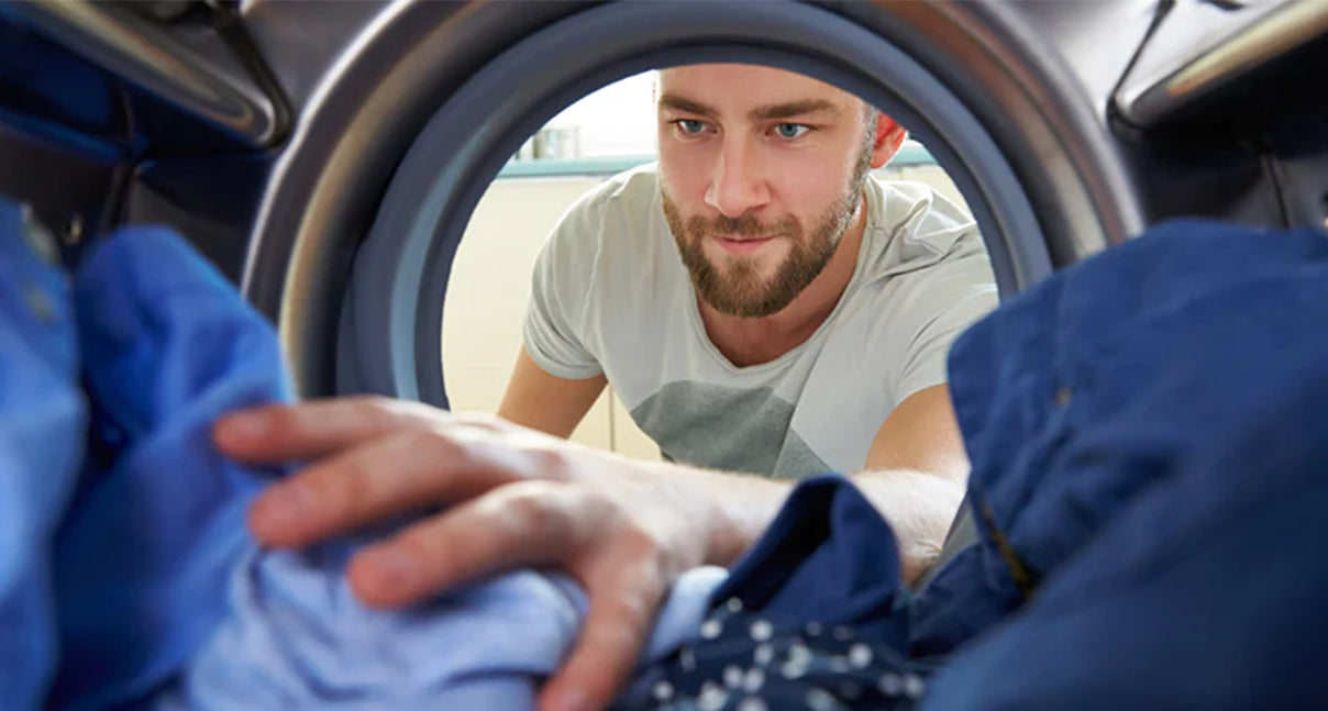 man reaching in washer