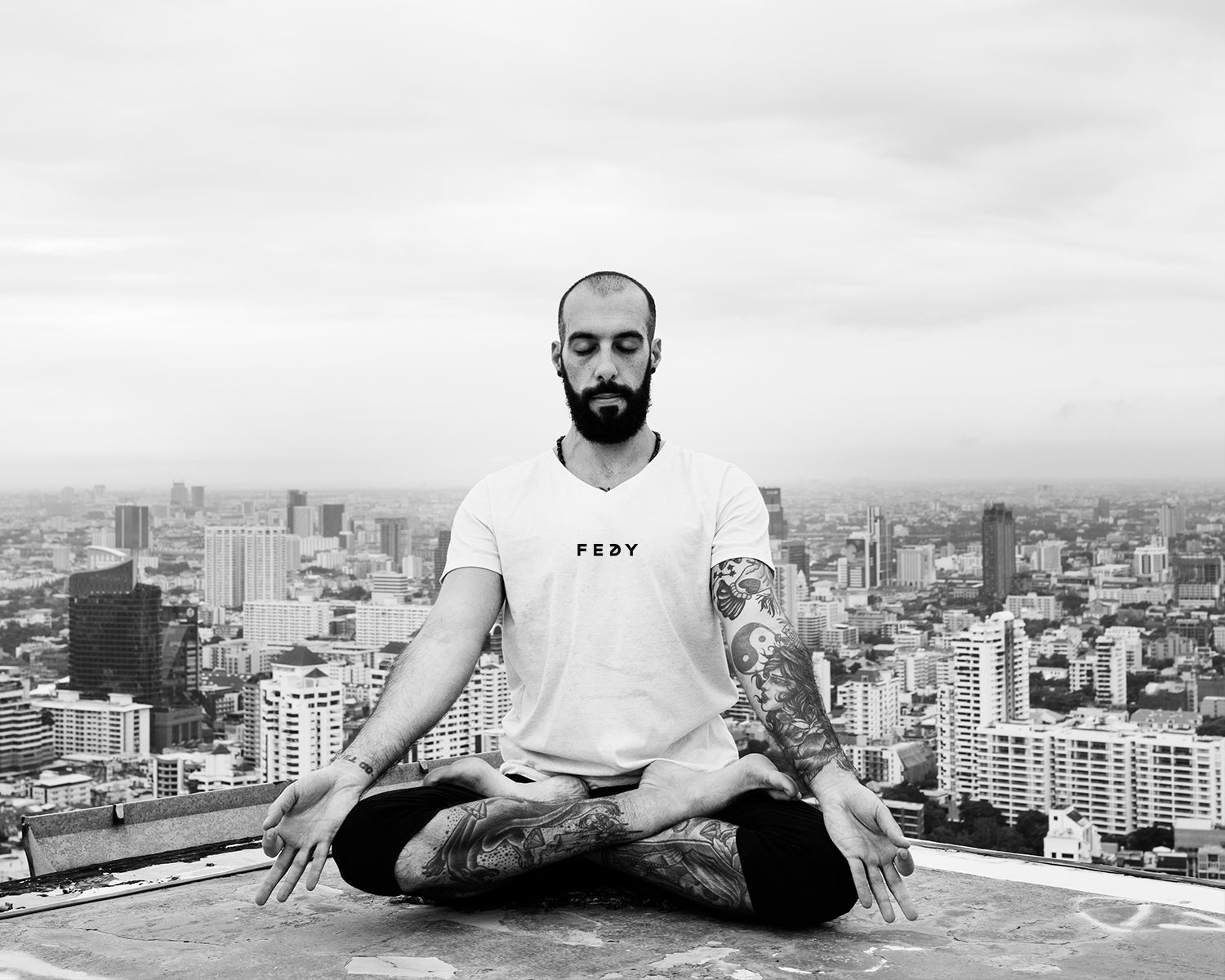 man meditating on top of building